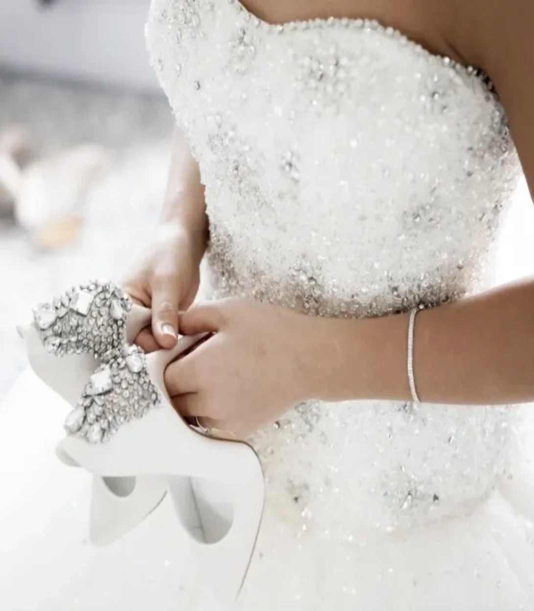 Bride adjusting her wedding dress with delicate lace and bubbles.