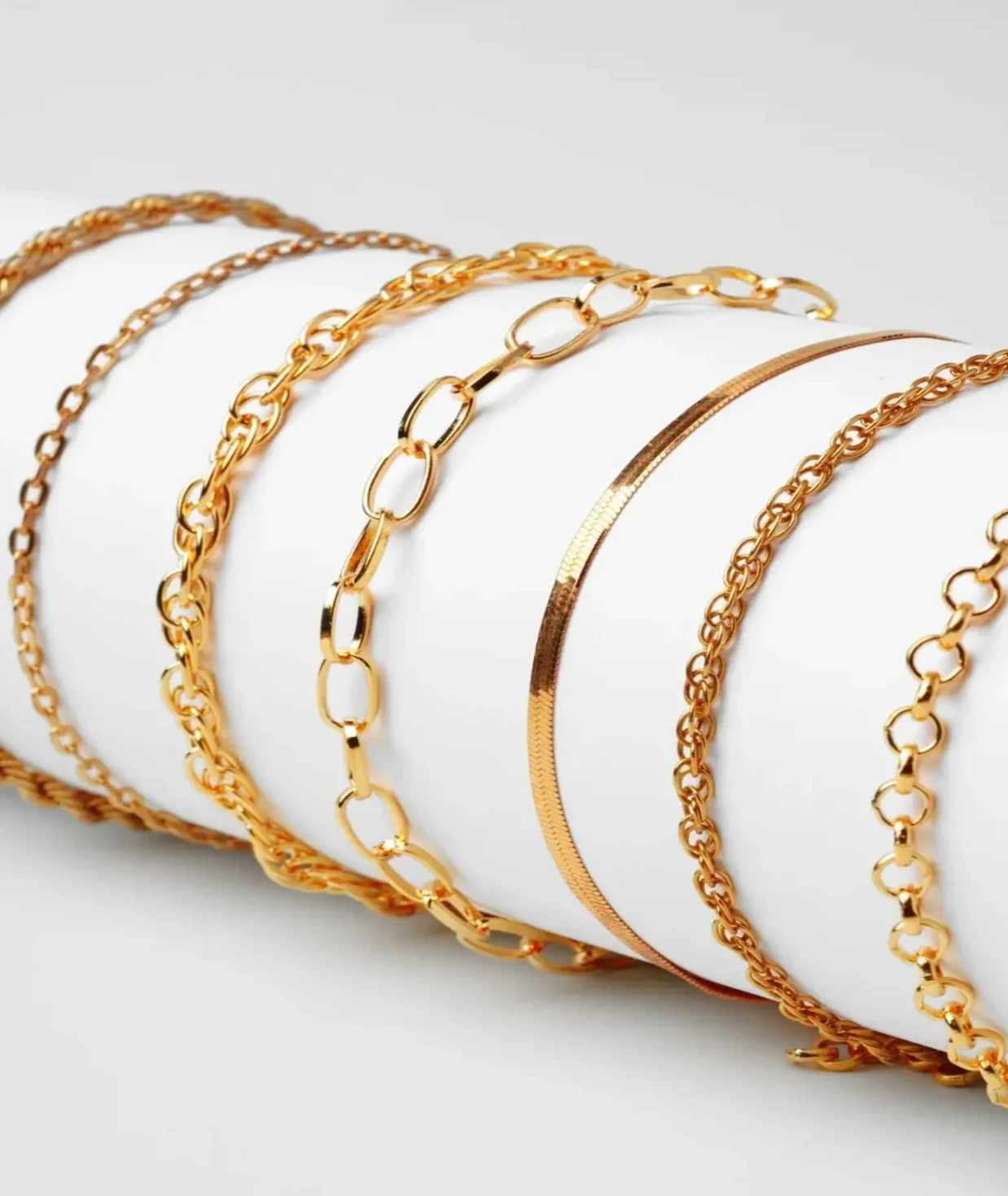 Collection of elegant gold bracelets with various designs.