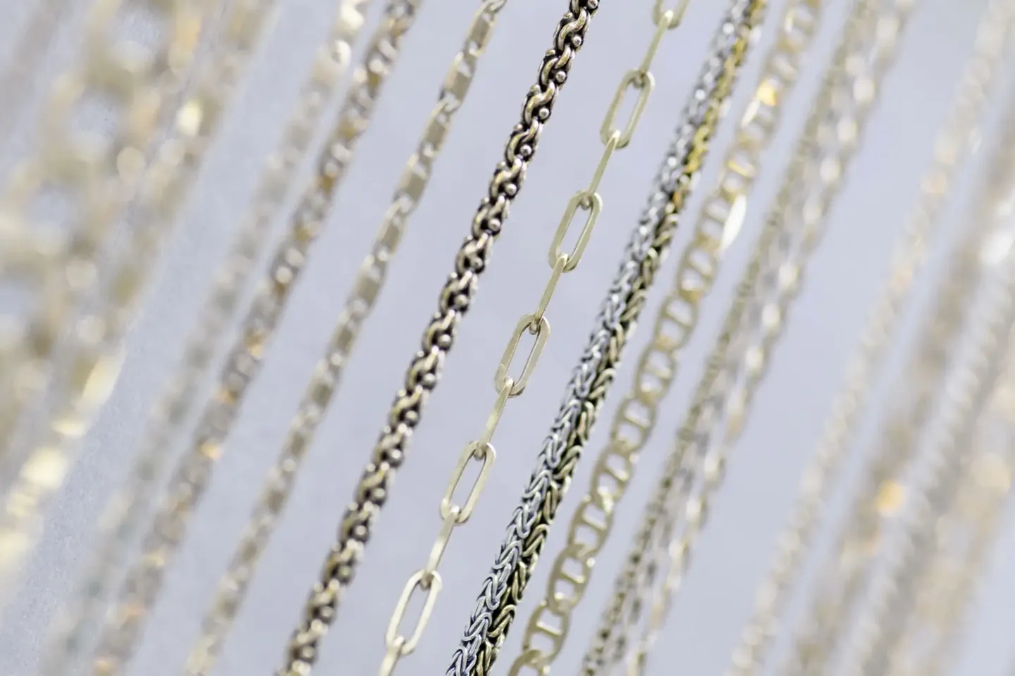 Close-up of various silver chains with different link designs.