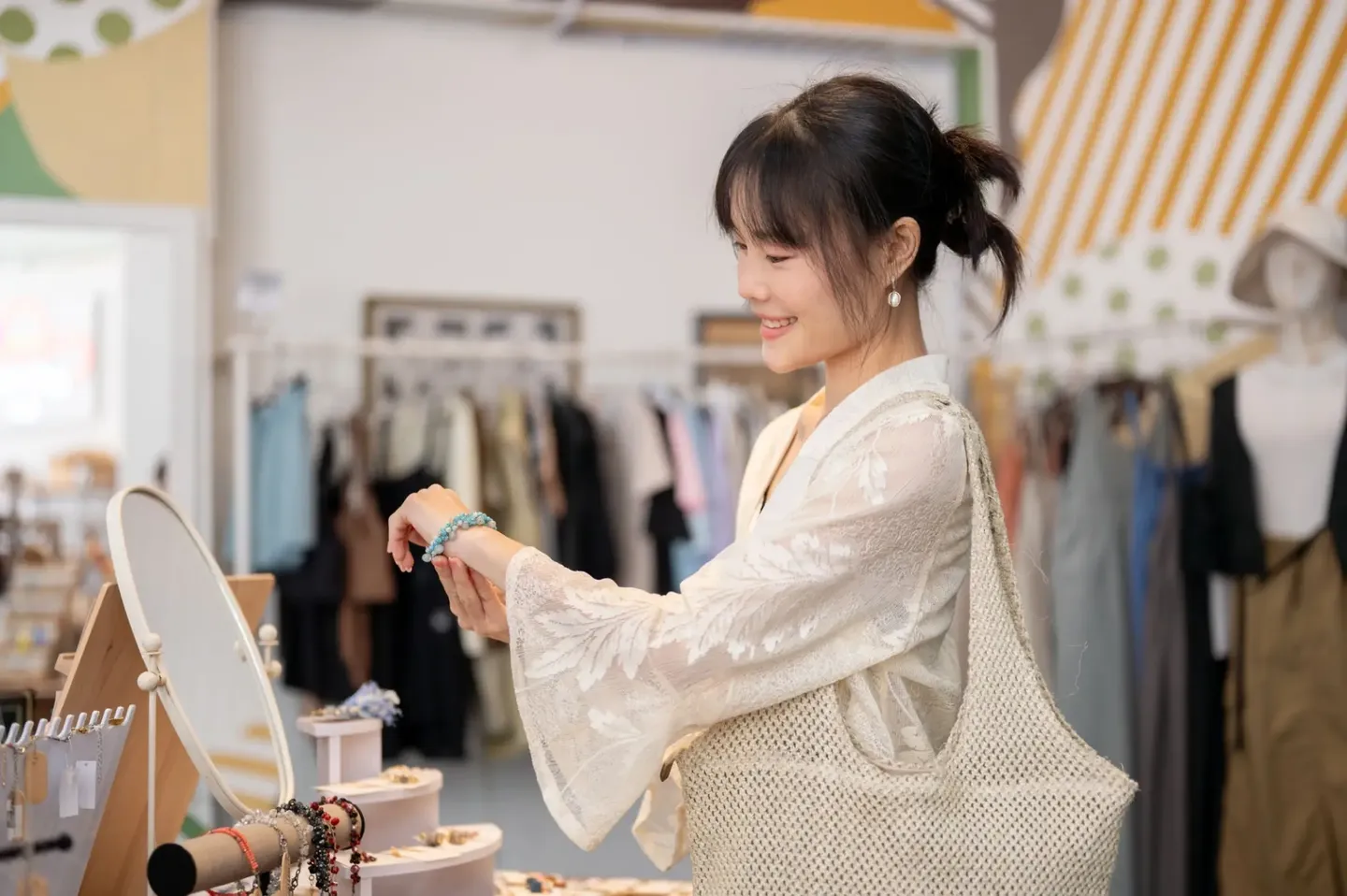 A woman smelling a flower in a cozy, softly lit room.